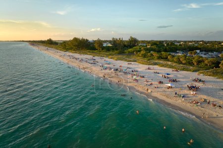 Aerial evening seascape with Nokomis sandy beach in Sarasota County, USA. Many tourists enjoing summer vacation time swimming in warm Mexico gulf water and sunbathing on hot Florida sun.