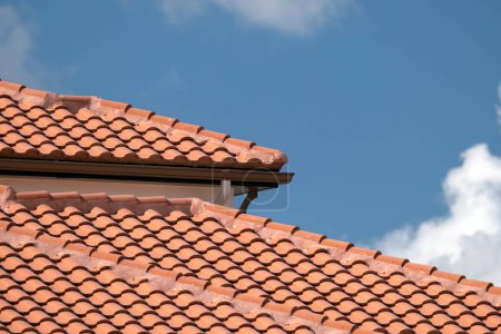 Überlappende Reihen gelber Keramik-Dachziegel bedecken das Dach eines Wohnhauses in Südflorida.