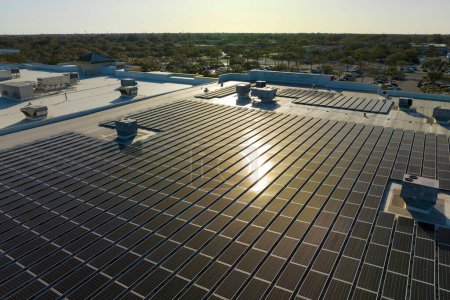 Foto de Paneles solares fotovoltaicos montados en el techo de un edificio industrial para producir electricidad ecológica verde. Producción del concepto de energía sostenible. - Imagen libre de derechos