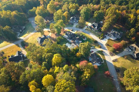 Luftaufnahme neuer Einfamilienhäuser zwischen gelben Bäumen in einem Vorort von South Carolina in der Herbstsaison. Immobilienentwicklung in amerikanischen Vorstädten.