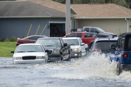 Foto de Inundado camino de Florida con coches de evacuación y rodeado de casas de agua en la zona residencial suburbana. Consecuencias del huracán desastre natural. - Imagen libre de derechos