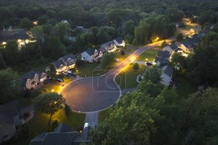 Photo for Aerial night view cul-de-sac road and spacious illuminated family houses in upstate New York suburban area. Real estate development in american suburbs. - Royalty Free Image