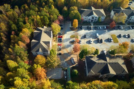 Aerial view of new apartment houses between yellow trees in South Carolina suburban area in fall season. Real estate development in american suburbs.