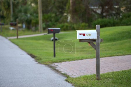 Téléchargez les photos : Boîte aux lettres américaine à la Floride maison devant la cour sur le côté de la rue de banlieue. - en image libre de droit