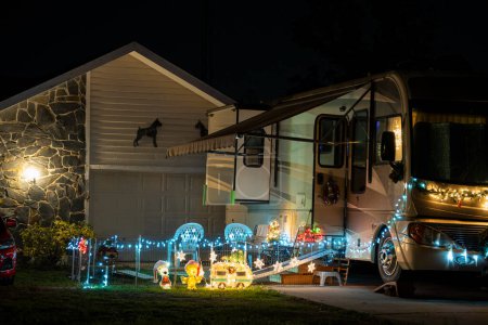 Téléchargez les photos : Décorations de Noël brillamment illuminées sur la cour avant près du camping-car. Décor extérieur pour les vacances d'hiver. - en image libre de droit