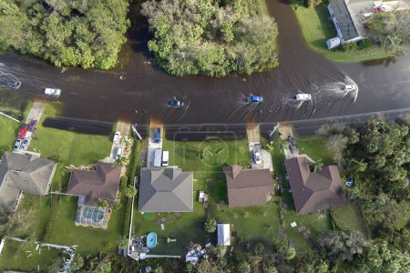 Hurrikan Ohnmacht überflutete Florida Straße mit evakuierenden Autos und umgeben von Wasserhäusern in vorstädtischem Wohngebiet.