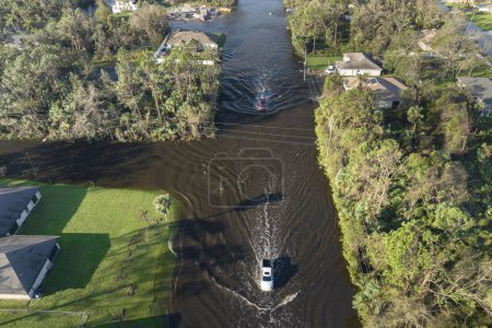 Luftaufnahme einer überfluteten Straße nach orkanartigen Regenfällen mit fahrenden Autos in einem Wohngebiet in Florida. Folgen von Naturkatastrophen.