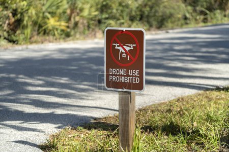 Photo for Signpost with warning about drone usage prohibition in state park. Warning notice against using UAV and quadcopters. - Royalty Free Image