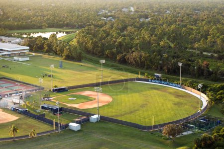 Vista aérea de las instalaciones deportivas al aire libre de la escuela secundaria en Florida. Estadio de fútbol americano, pista de tenis e infraestructura deportiva de diamantes de béisbol.