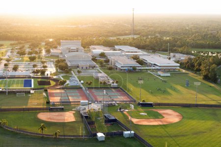 Téléchargez les photos : Vue aérienne des installations sportives en plein air du secondaire en Floride. Stade de football américain, court de tennis et infrastructure sportive de terrain de baseball. - en image libre de droit