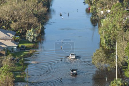 Inondé route de Floride avec des voitures d'évacuation et entouré de maisons d'eau dans un quartier résidentiel de banlieue. Conséquences de l'ouragan catastrophe naturelle.