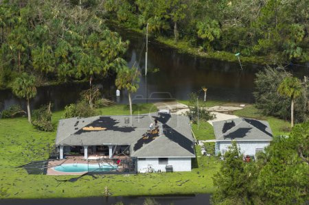 Destroyed house roof by hurricane Ian strong winds in Florida residential area. Natural disaster and its consequences.