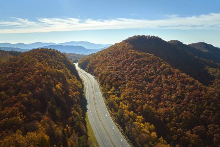 View from above of empty deserted I-40 freeway route in North Carolina leading to Asheville thru Appalachian mountains with yellow fall woods. Interstate transportation concept.