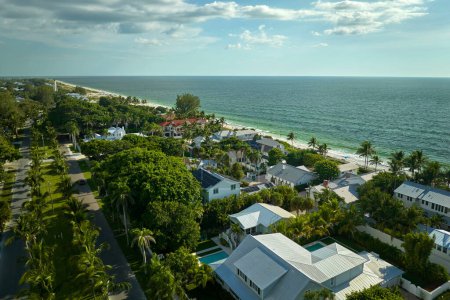 Teure Häuser am Wasser zwischen grünen Palmen in Boca Grande, einer Kleinstadt auf der Insel Gasparilla im Südwesten Floridas. Premiumwohnungsbau in den USA.
