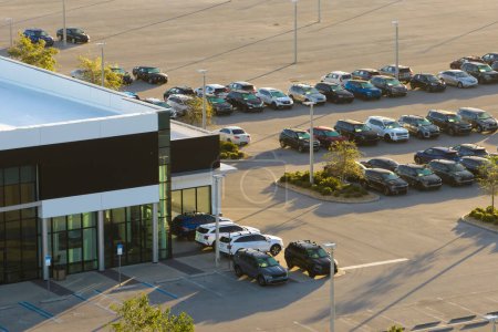 Großer Parkplatz des örtlichen Händlers mit vielen nagelneuen Autos, die zum Verkauf stehen. Entwicklung der amerikanischen Automobilindustrie und Vertrieb von Fertigungsfahrzeugen.