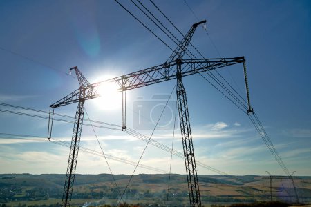 pilier en acier avec lignes électriques à haute tension fournissant de l'énergie électrique à travers des câbles sur de longues distances.