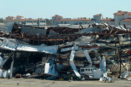 Warehouse with motorboats and yachts destroyed by hurricane winds in Florida coastal area. Natural disaster and its consequences.