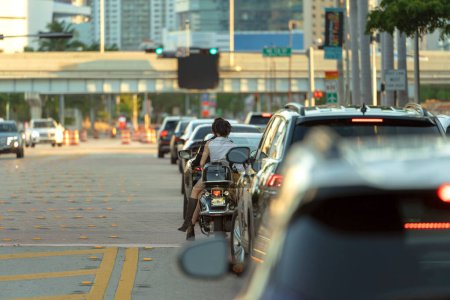 Motorrad- und Autoverkehr an einer Kreuzung auf der amerikanischen Straße mit Ampeln in Miami, Florida. Verkehr in den USA.