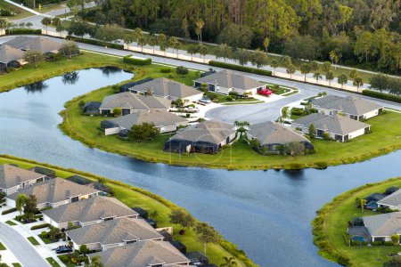 Blick von oben auf Wohnhäuser in Wohngebiet in North Port, Florida. Amerikanische Traumhäuser als Beispiel für Immobilienentwicklung in US-Vorstädten.