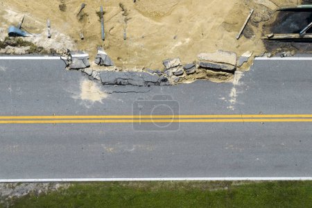 Destroyed bridge after hurricane flooding in Florida. Construction roadwork site. Reconstruction of damaged road after flood water washed away asphalt.