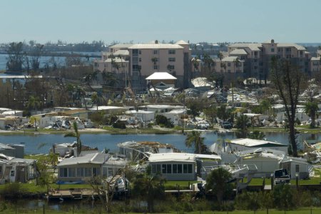 Hurricane strong wind destroyed suburban house roofs in Florida mobile home residential area. Consequences of natural disaster.