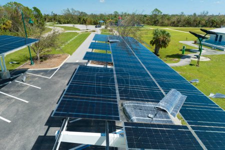 Hurrikan-Windschäden an Sonnenkollektoren, die als Schattendach über dem Parkplatz für geparkte Elektroautos installiert wurden. Versagen der Photovoltaik-Technologie in städtische Infrastruktur integriert.