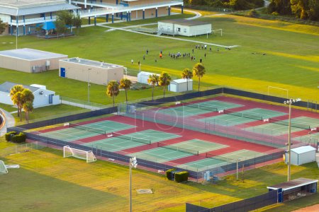 Tennis court in American public school backyard for students physical education in rural Florida. Open air ballpark sport infrastructure.