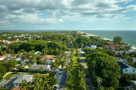 Wealthy neighborhood in small town Boca Grande, Florida with expensive waterfront houses between green palm trees. Development of US premium housing.