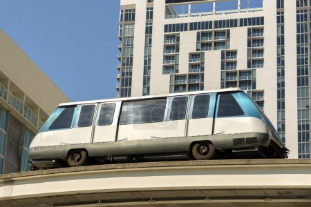 Nahverkehr in der Innenstadt von Miami Brickell in Florida USA. Metrorail City Train Car auf der Hochbahn über den Straßenverkehr zwischen Wolkenkratzern in der modernen amerikanischen Megapolis.