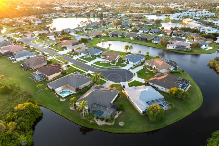 Die Sackgasse der Sackgasse bei Sonnenuntergang und private Wohnhäuser in einem ländlichen Vorortgebiet in North Port, Florida. Gehobene Vorstadthäuser mit großen Hinterhöfen am Wasser.