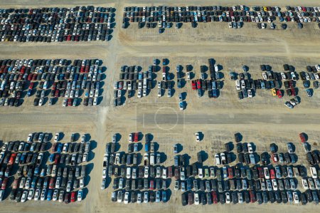 Aerial view of auction reseller company big parking lot with parked cars ready for remarketing services. Sales of secondhand vehicles.