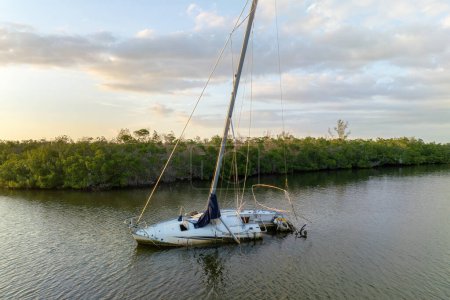 Chaviré voilier coulé gauche abandonné sur les eaux peu profondes de la baie après l'ouragan Ian à Manasota, Floride.
