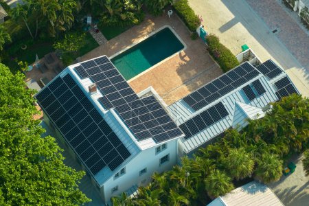 Grande maison neuve aux Etats-Unis avec toit recouvert de panneaux solaires photovoltaïques pour la production d'énergie électrique écologique propre dans les zones rurales de banlieue. Concept de maison autonome.
