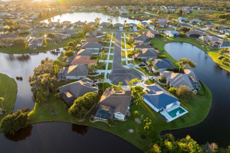 Die Sackgasse der Sackgasse bei Sonnenuntergang und private Wohnhäuser in einem ländlichen Vorortgebiet in North Port, Florida. Gehobene Vorstadthäuser mit großen Hinterhöfen am Wasser.