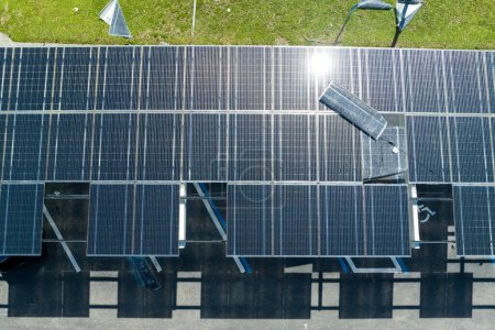 Dañado por el viento huracán paneles solares fotovoltaicos montados en el techo del toldo del estacionamiento para producir electricidad ecológica verde. Consecuencias del desastre natural en Florida, EE.UU..