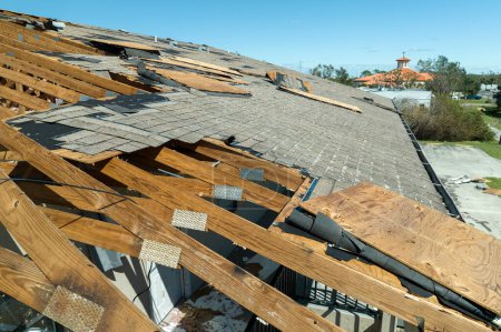 Téléchargez les photos : Toit en ruine dans le besoin de réparation. Toit de la maison endommagé par le vent avec bardeaux d'asphalte manquants après l'ouragan Ian en Floride. - en image libre de droit
