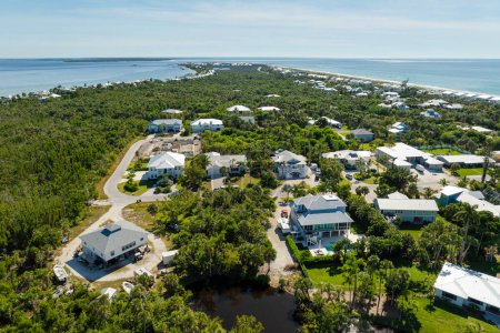 Wealthy neighborhood in small town Boca Grande, Florida with expensive waterfront houses between green palm trees. Development of US premium housing.