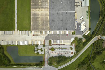 Foto de Vista aérea de un gran centro de distribución comercial con muchos camiones descargando y cargando productos minoristas para su posterior envío. Concepto de economía global. - Imagen libre de derechos