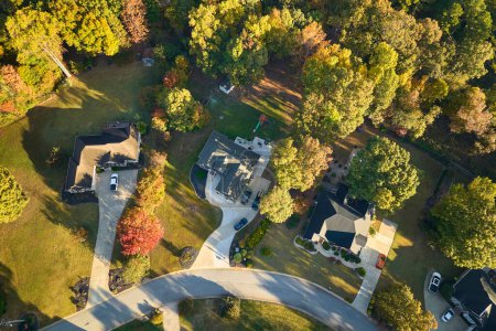 Aerial view of new family houses between yellow trees in South Carolina suburban area in fall season. Real estate development in american suburbs.