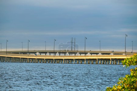 Barron Collier Bridge and Gilchrist Bridge in Florida with moving traffic. Transportation infrastructure in Charlotte County connecting Punta Gorda and Port Charlotte over Peace River.