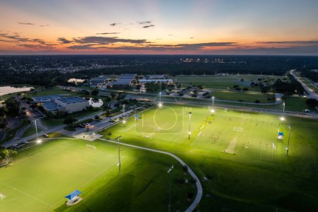 Téléchargez les photos : Des sportifs jouent au football sur un stade illuminé dans un parc sportif public. - en image libre de droit