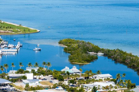 Premium housing development in the USA. Expensive waterfront houses between green palm trees in Boca Grande, small town on Gasparilla Island in southwest Florida.