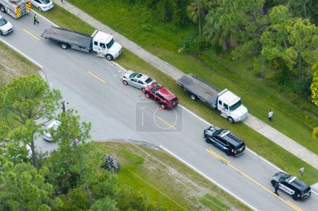 Vista superior de los socorristas en el lugar del accidente de coche en Florida. Personal de servicios de emergencia ayudando a víctimas de accidente de coche en la calle de la ciudad en EE.UU..