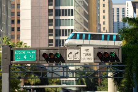 Voiture de train de ville sur le chemin de fer élevé sur le trafic de rue entre les bâtiments de gratte-ciel dans la mégapole américaine moderne. Transport urbain dans le centre-ville de Miami Brickell en Floride États-Unis.