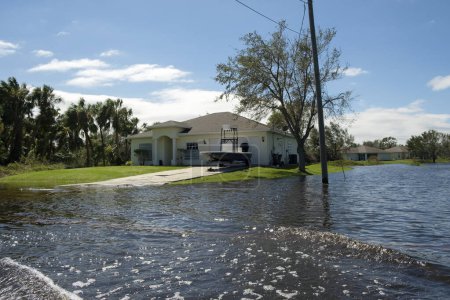 Flooded american street in Florida residential area. Hazardous driving conditions. Consequences of hurricane natural disaster.