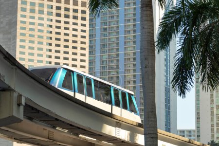 Train surélevé pour les transports en commun dans le centre-ville de Miami en Floride États-Unis. Métrorail train sur le chemin de fer sur le trafic de rue entre les bâtiments gratte-ciel dans la zone urbaine américaine moderne.
