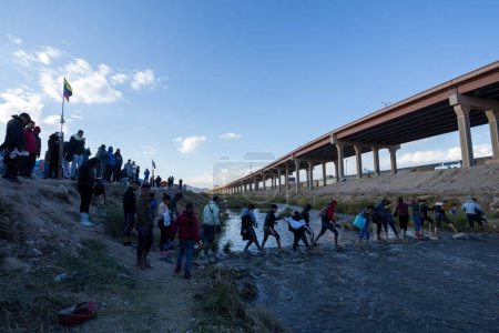 Photo for Juarez, Mexico, 11-15-2022: Migrants from Venezuela cross the Rio Grande to surrender to the border patrol with the intention of requesting asylum in the United States. - Royalty Free Image