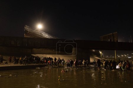 Foto de Juárez, México, 11-12-2022: 1400 migrantes, en su mayoría de Bolivia y Nicaragua, cruzan la frontera en una caravana en Juárez para rendirse a la patrulla fronteriza y solicitar asilo humanitario. - Imagen libre de derechos