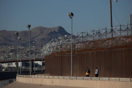 Foto de Juarez, Mexico, 11-28-2022: Migrants from Venezuela cross the Rio Grande to surrender to the border patrol with the intention of requesting asylum in the United States. - Imagen libre de derechos