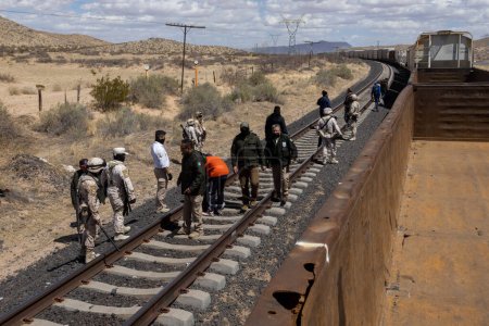Téléchargez les photos : Des agents d'immigration et la Garde nationale mènent une opération à bord du train "La Bestia" pour empêcher les migrants de voyager à bord - en image libre de droit